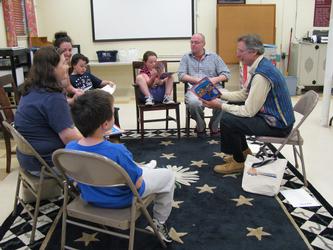 Storyteller Tim Van Egmond reads with the Beland family and the Lynch family