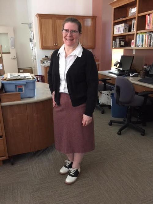 Library Staff member, Robin B. getting reading to model fashion of the past 100 years.